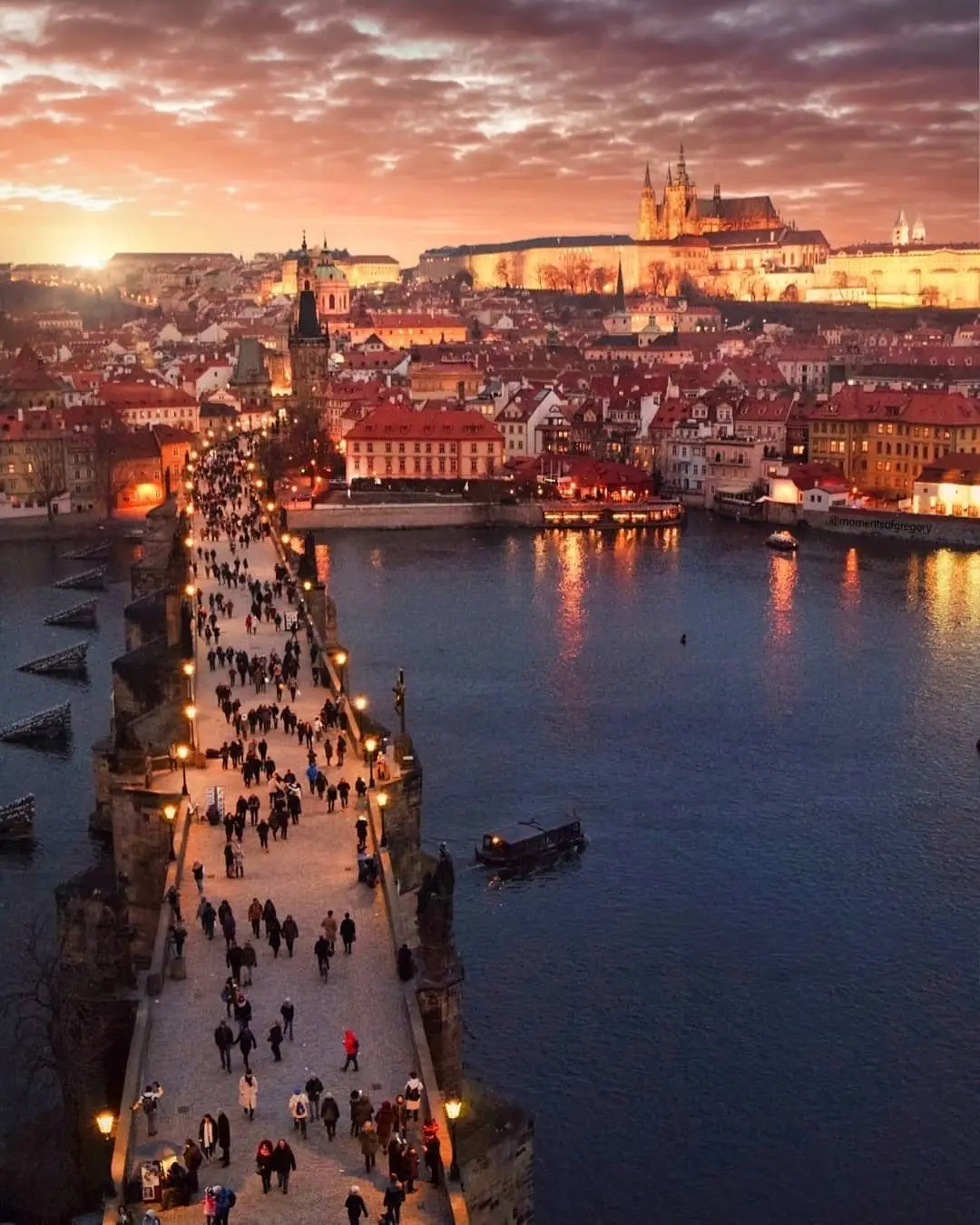 Karlův most z hladiny Vltavy, poslední sluneční paprsky na sochách